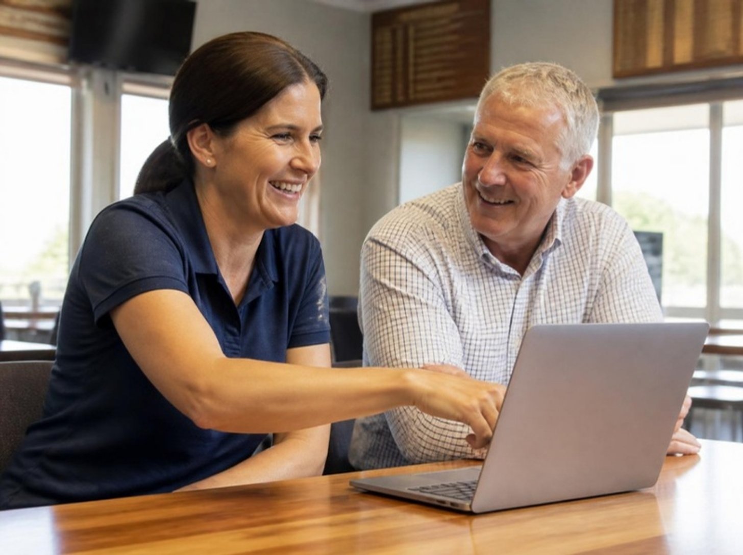 Zwei Menschen aus dem Vorstand sitzen nebeneinander, einer erklärt dem anderen etwas am Laptop